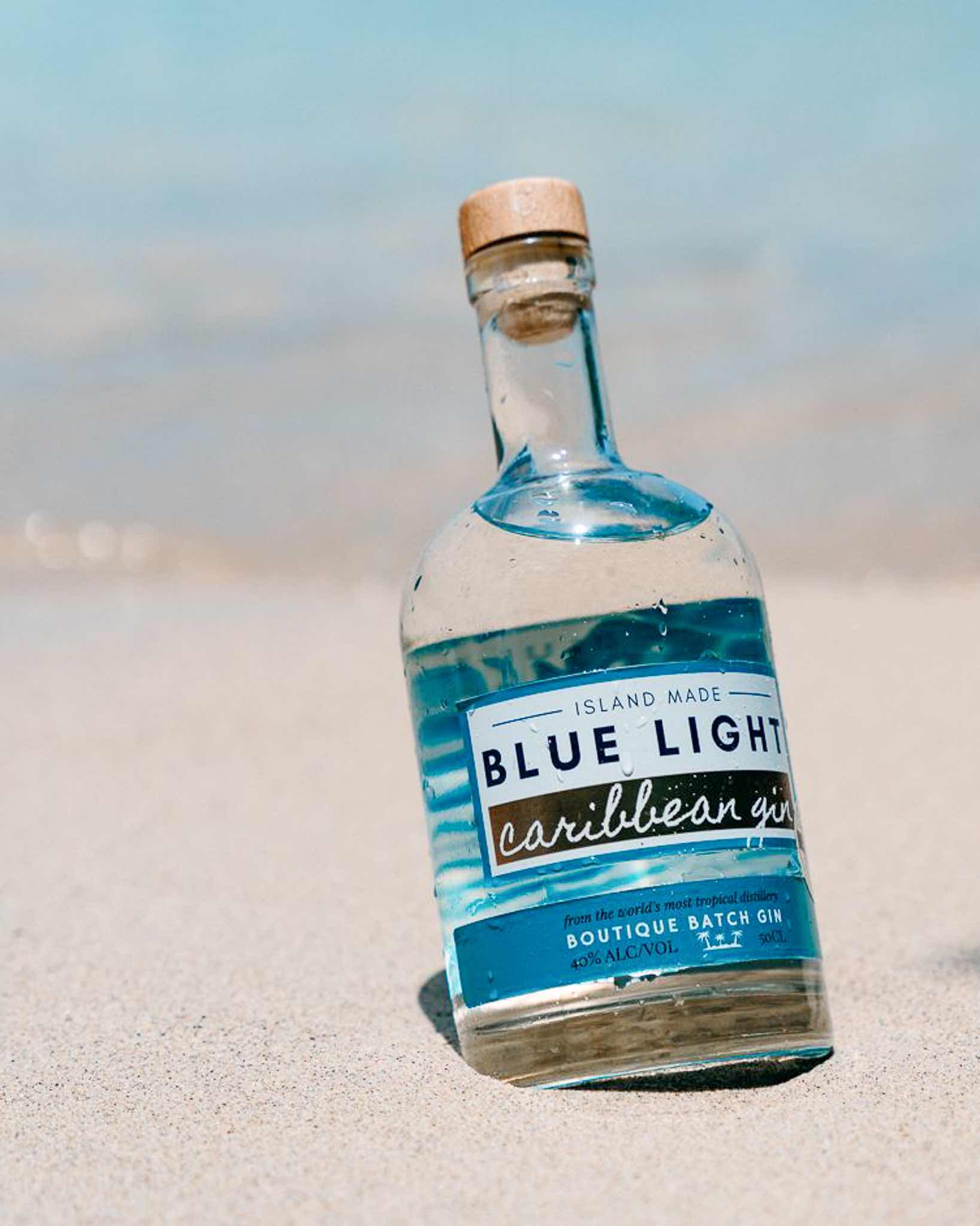 Blue Light Caribbean Gin bottle on the beach
