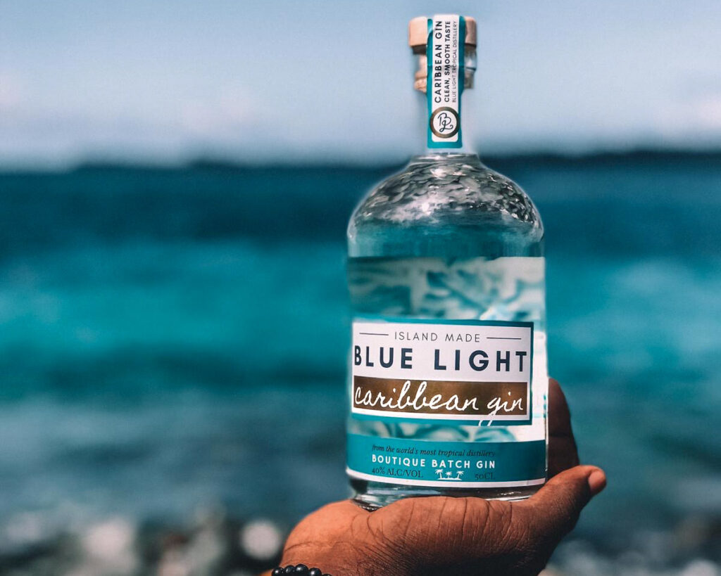blue light Caribbean Gin bottle with ocean